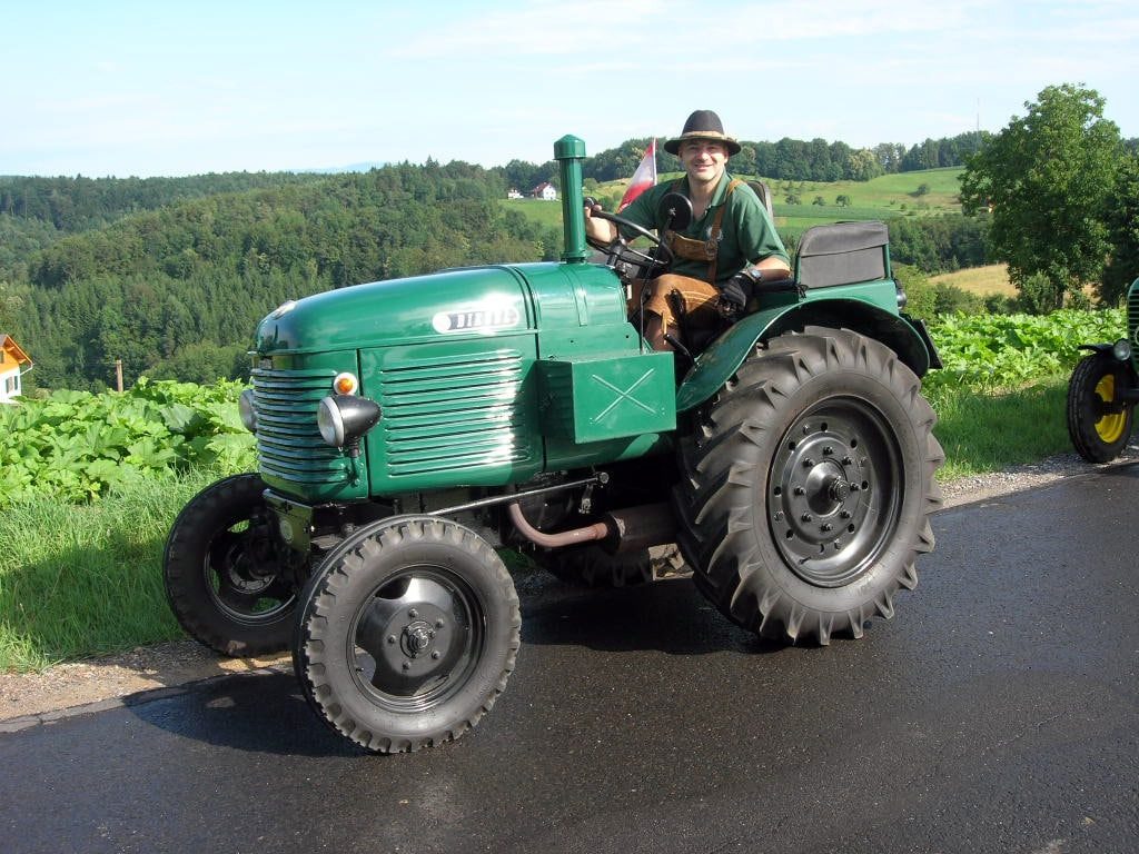 Vereinsmitglied in Tracht auf seinem restaurierten grünen Steyr-Oldtimer-Traktor bei einer Ausfahrt in Markt Hartmannsdorf
